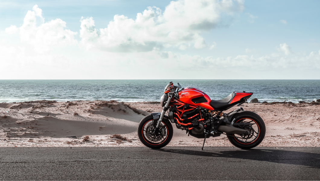 Red motorbike by a beach