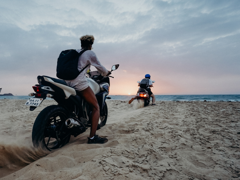 Men riding motorbike on beach